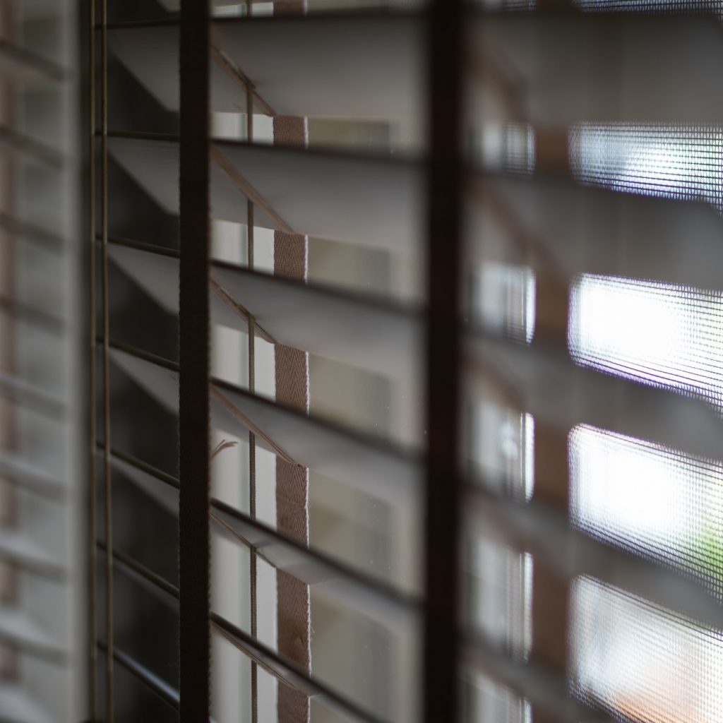 Timber venetian blinds on window casting shadows
